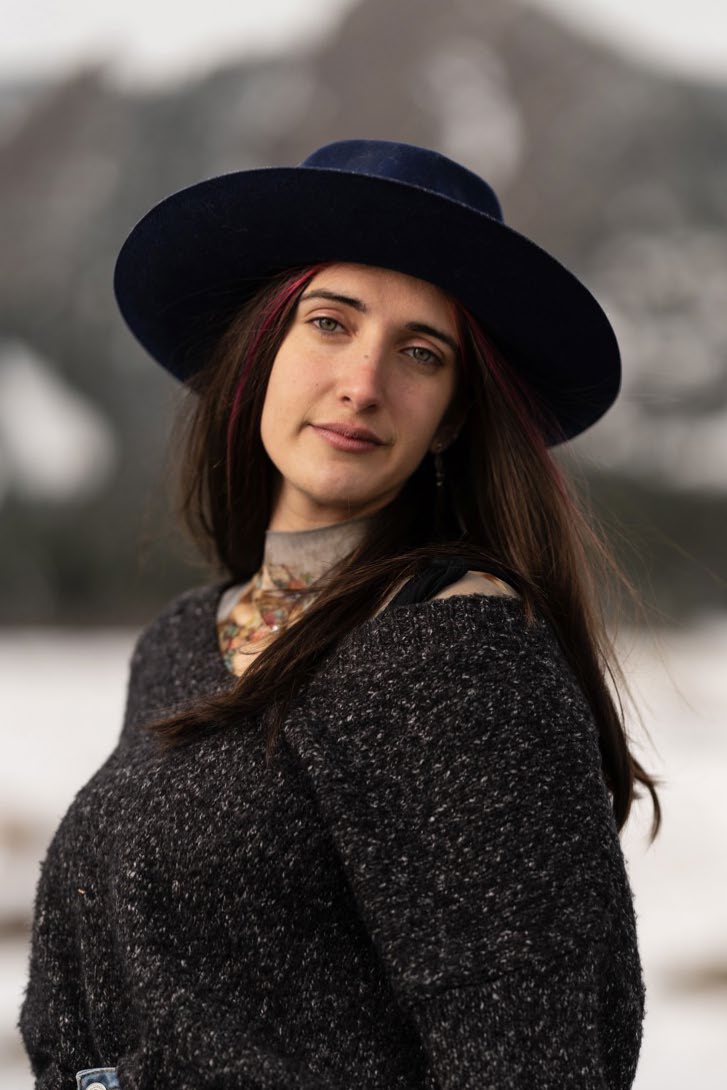 Portrait of Skye Reich wearing a wide-brimmed hat outdoors.